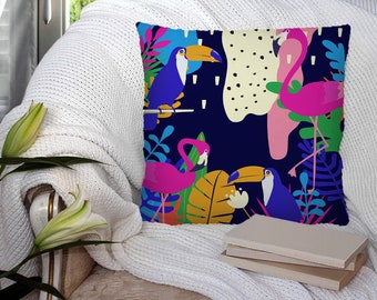 May include: A colourful throw pillow with a tropical design featuring toucans and flamingos on a dark blue background. The pillow has a variety of green, yellow, pink, and blue colours.
