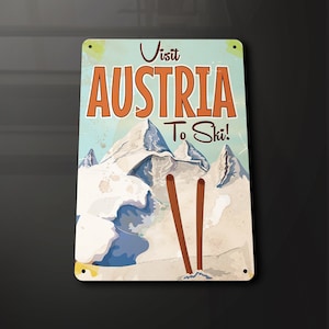 Puede incluir: Señal de metal de estilo vintage con una ilustración azul y blanca de montañas nevadas y dos bastones de esquí. La señal dice "Visita Austria para esquiar!" en texto naranja.