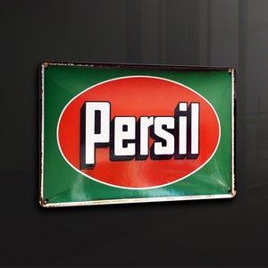 Puede incluir: Un letrero de esmalte vintage con un círculo rojo y texto blanco que dice "Persil" sobre un fondo verde.