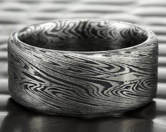 May include: A silver ring with a unique woodgrain pattern. The ring is made of metal and has a smooth, polished finish.
