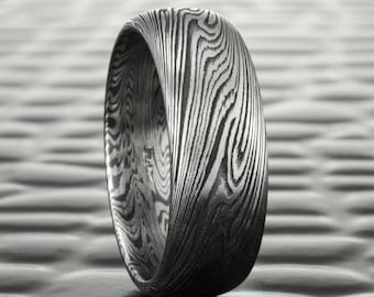 May include: A silver ring with a unique wood grain pattern. The ring is made of metal and has a polished finish.