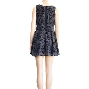 May include: A black and gray sleeveless dress with a floral pattern. The dress has a fitted bodice and a flared skirt. The dress is shown on a mannequin.