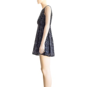 May include: A sleeveless black and gray floral print dress with a fitted bodice and a flared skirt. The dress is worn by a mannequin with black heels.