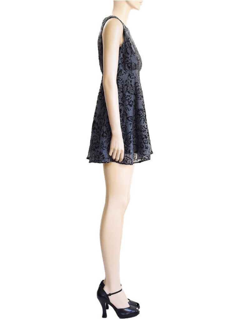 May include: A sleeveless, knee-length dress with a black floral pattern on a gray background. The dress has a fitted bodice and a flared skirt.