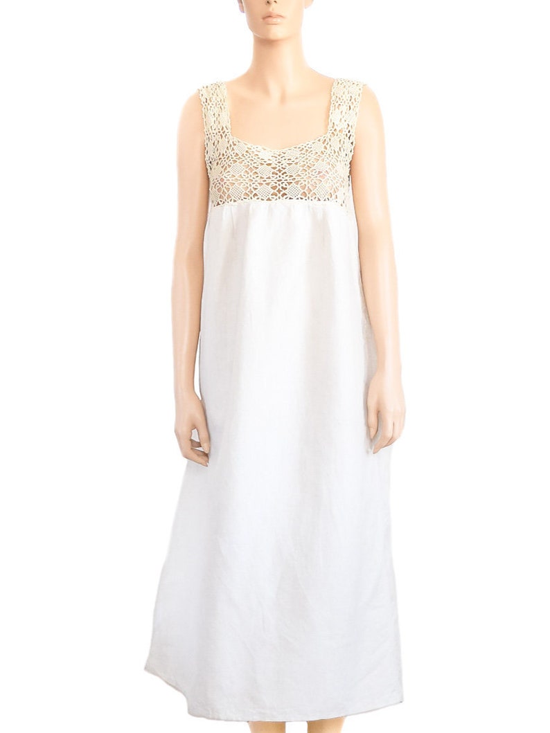 May include: A white linen dress with a crocheted lace bodice. The dress has a sleeveless design and a flowing skirt.