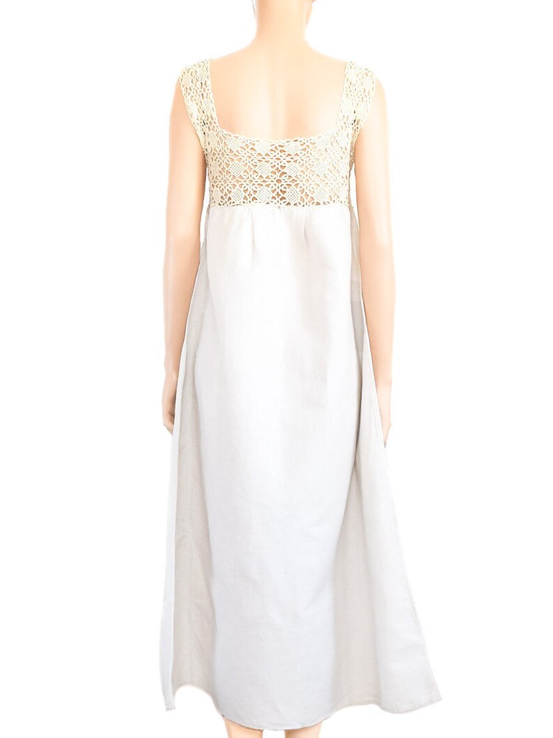 May include: A white maxi dress with a crocheted bodice. The dress has a simple, flowy silhouette and is perfect for a summer day.