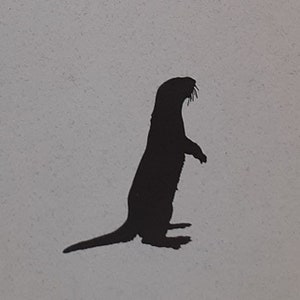 May include: A black silhouette of an otter standing on its hind legs with its front paws raised. The otter is facing to the right and has a long, slender tail.
