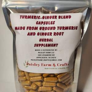 May include: A clear plastic bag filled with a large quantity of yellow-orange capsules. The bag has a white label with the text "TURMERIC-GINGER BLEND CAPSULES MADE FROM GROUND TURMERIC AND GINGER ROOT HERBAL SUPPLEMENT MADE & DISTRIBUTED BY: PAISLEY FARM LLC 1852 SYCAMORE RD APPALACHIA, VA 24216 PAISLEYFARM.CRAFTS@GMAIL.COM Paisley Farm & Crafts Made Fresh For A Healthy You".