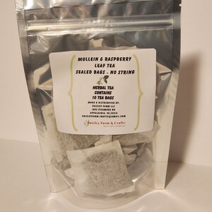 May include: A silver resealable bag filled with 10 individual tea bags containing a blend of mullein and raspberry leaf tea. The label reads "Mullein & Raspberry Leaf Tea, Sealed Bags - No String, Herbal Tea Contains 10 Tea Bags, Made & Distributed by: Paisley Farm LLC, 1852 Sycamore Rd, Appalachia, VA 24216, Paisleyfarm Crafts@gmail.com, Paisley Farm & Crafts".