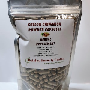 May include: A silver resealable bag filled with brown capsules labeled "Ceylon Cinnamon Powder Capsules Herbal Supplement" made by Paisley Farm & Crafts. The label includes the company's address and email.