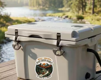 May include: A light gray hard-sided cooler featuring a circular sticker with a mountain landscape, a snail, and the text "WEST VIRGINIA SLOW HIKING SOCIETY BE THERE IN A MINUTE" printed in black, orange, and green colors on the front surface.