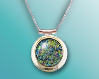 May include: A silver chain necklace with a round pendant featuring a colorful, iridescent glass design set in a gold-toned frame.
