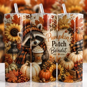 Peut inclure: Un gobelet cylindrique avec une paille transparente illustré d'un raton laveur portant un bonnet et une écharpe à carreaux, tenant un café. Le motif inclut des tournesols, des citrouilles, des feuilles d'automne et le texte Pumpkin Patch Bandit.