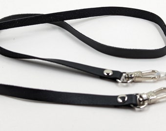 May include: Black leather eyeglass chain with silver clasps and spring-loaded eyeglass holders.