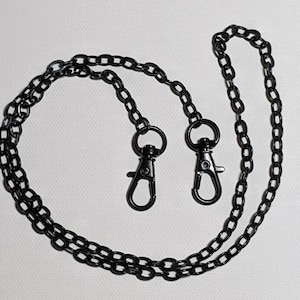 May include: Black chain with two metal clasps. The chain is double-stranded and has a matte finish.