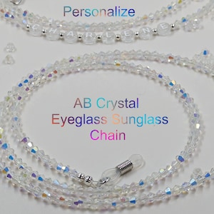 May include: A clear crystal eyeglass chain with silver clasps. The chain is made of AB crystal beads and is approximately 28 inches long.  The text "AB Crystal Eyeglass Sunglass Chain" is written in rainbow colors below the chain.