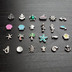 May include: A collection of 20 silver charm beads with various ocean-themed designs, including anchors, seashells, sea turtles, starfish, palm trees, and a sailboat. The charms are perfect for adding a nautical touch to jewelry.