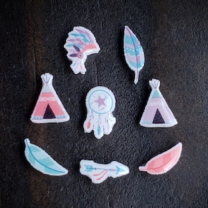 May include: A set of eight colorful felt cutouts featuring various Native American inspired designs, including a teepee, a dreamcatcher, and feathers. The cutouts are perfect for crafting projects, scrapbooking, or adding a touch of Native American style to your home decor.