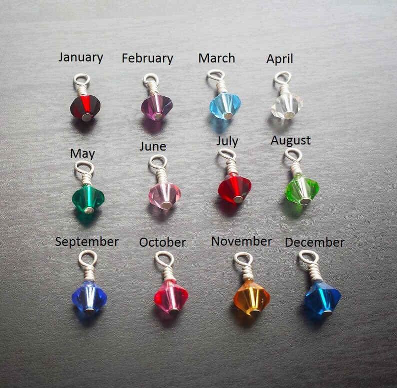 May include: Twelve crystal charms, each representing a month of the year. The charms are silver-toned and have a small loop at the top. The crystals are in various colors, including red, pink, blue, green, and clear.