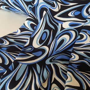 Pode incluir: Close-up de um tecido com um padrão de redemoinho em tons de azul, branco e preto.