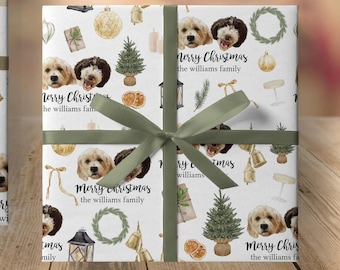 May include: Two wrapped gifts with a festive dog-themed pattern. The white wrapping paper features illustrations of dogs, Christmas trees, and ornaments. The gifts are tied with a light green ribbon, and the text "Merry Christmas the williams family" is visible.