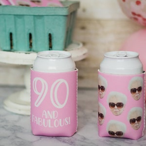 May include: Two pink can coolers. One cooler has the number 90 and the words "and fabulous!" printed on it. The other cooler has a pattern of a woman wearing sunglasses.