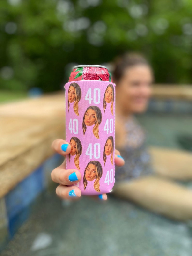 May include: Pink can cooler with a repeated pattern of a woman's face and the number 40.