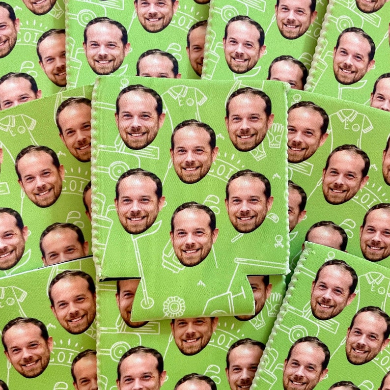 May include: Green and white can cooler with a repeating pattern of faces and golf-related imagery. The cooler has a zipper closure and a handle.