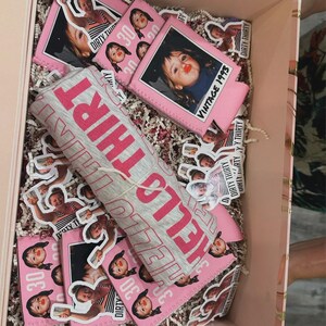 May include: A gift box containing a grey t-shirt with the pink text HELLO THIRTY, several pink foam can coolers featuring the text VINTAGE 1993 and DIRTY THIRTY, and numerous small stickers showing photos of a person and the text DIRTY THIRTY.