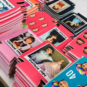 May include: A collection of foam beverage insulators in various colors including pink, black, and teal. The insulators feature printed photographs of children, people, and balloon art, with text such as Vintage 1984, Vintage 1991, and the number 40.
