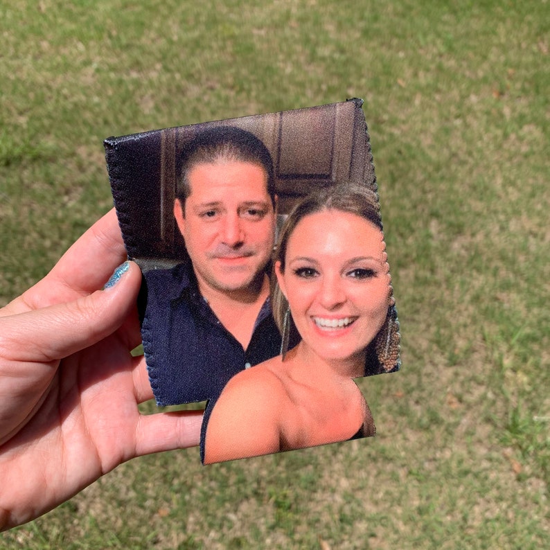 May include: A black and white photo of a couple on a can cooler. The man is wearing a dark shirt and the woman is wearing a white top. The can cooler is made of neoprene and has a zipper closure.