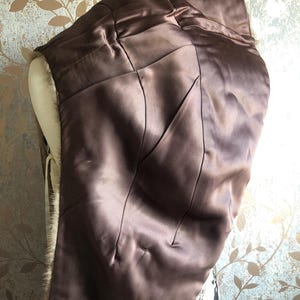 May include: A brown fur coat with a satin lining. The lining is a dark brown colour and has a quilted pattern. The fur is a light brown colour and is very soft.