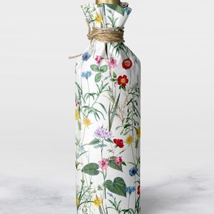 A bottle wrapped in wild flower tissue paper with hemp string at the neck