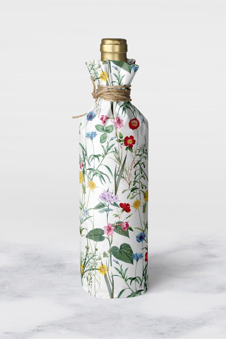 A bottle wrapped in wild flower tissue paper with hemp string at the neck