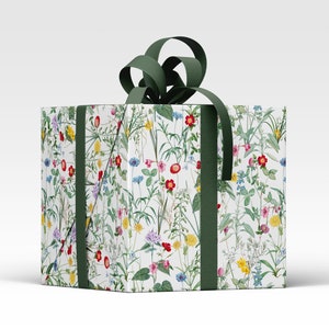 A parcel wrapped in wild flower wrapping paper with a green ribbon