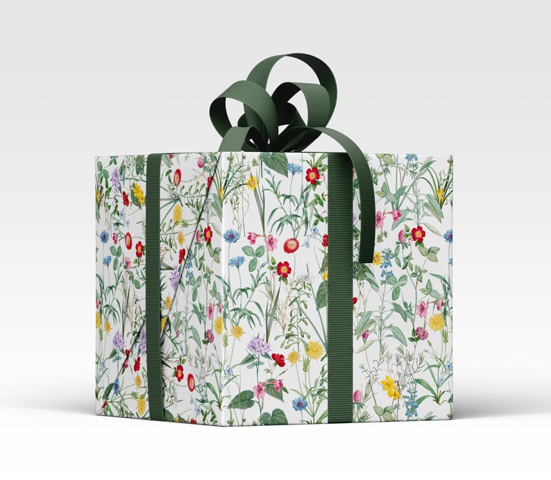 A parcel wrapped in wild flower wrapping paper with a green ribbon