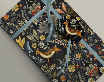 May include: Black wrapping paper with a repeating pattern of stylized floral designs, leaves, and deer. The paper is decorated with a blue ribbon.