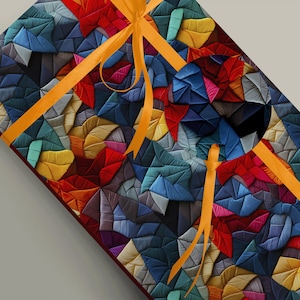 May include: A colorful gift box wrapped in a geometric pattern of fabric squares in shades of blue, red, yellow, green, and purple. The box is tied with a bright orange ribbon.