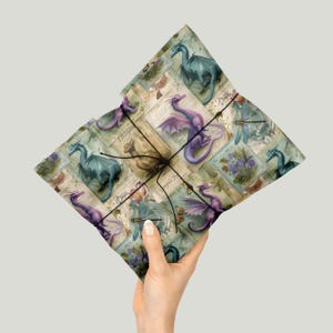 May include: A wrapped gift held in a hand, with a repeating pattern of dragons in purple, blue, and brown on a vintage background. The gift is tied with black twine.