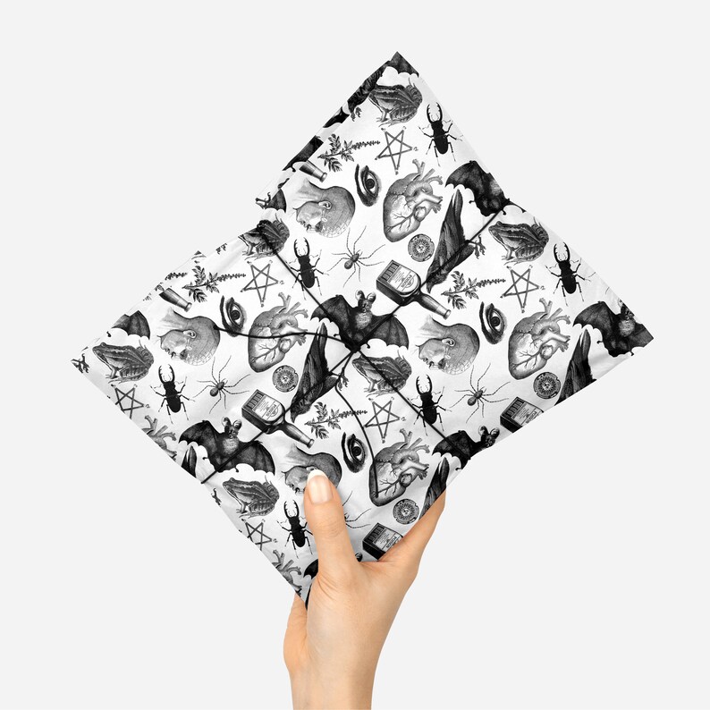 Monochrome witch craft artwork on tissue paper being held in a hand