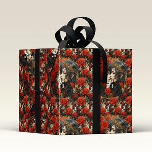 May include: A black gift box with a black ribbon and a floral pattern. The pattern features red roses and a repeated image of two women with long dark hair.