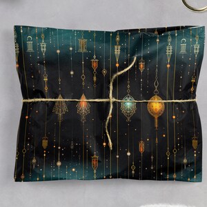 Puede incluir: Papel de regalo verde oscuro con un patr&oacute;n geom&eacute;trico dorado de linternas colgantes y estrellas. El papel est&aacute; atado con una cuerda de yute natural.