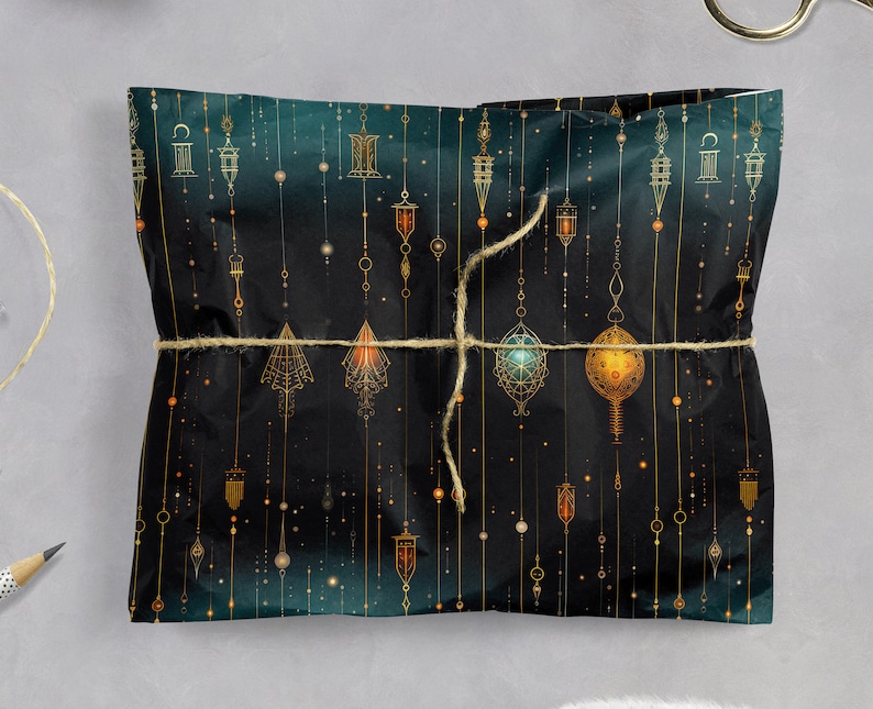 Puede incluir: Papel de regalo verde oscuro con un patr&oacute;n geom&eacute;trico dorado de linternas colgantes y estrellas. El papel est&aacute; atado con una cuerda de yute natural.