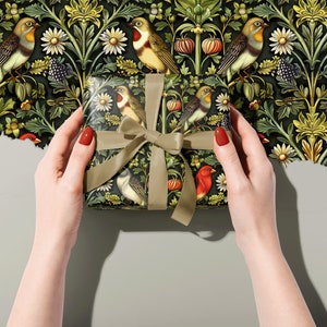 May include: A gift box wrapped in green and black patterned paper featuring birds and flowers. The paper has a vintage aesthetic.