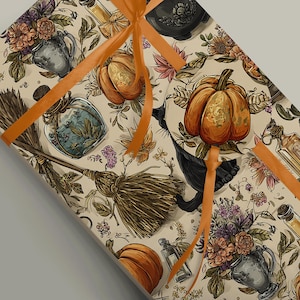 Peut inclure: Papier cadeau avec un motif répété de citrouilles, de flacons de potion, de fleurs et d'un balai sur fond crème. Un ruban orange est noué autour du paquet. Le thème général est Halloween ou l'automne.