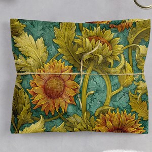 Puede incluir: Un paquete envuelto con un llamativo dise&ntilde;o floral. El patr&oacute;n presenta grandes girasoles en tonos amarillos y naranjas sobre un fondo turquesa. El paquete est&aacute; atado con hilo, lo que sugiere un regalo o un art&iacute;culo decorativo.