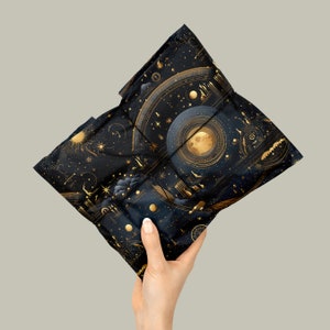 Moon phase and Zodiac Gift Wrapping Paper around a parcel with a Gold Ribbon held in a hand