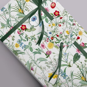 A parcel wrapped in wild flower wrapping paper with a green ribbon