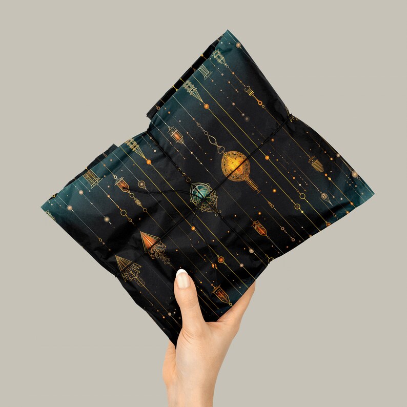 Puede incluir: Una bolsa de regalo negra con un patr&oacute;n geom&eacute;trico dorado y verde. El patr&oacute;n presenta un dise&ntilde;o repetitivo de adornos colgantes y l&iacute;neas.