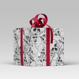 Wrapping paper featuring skulls shown wrapping a gift with gift tag and red ribbon.
